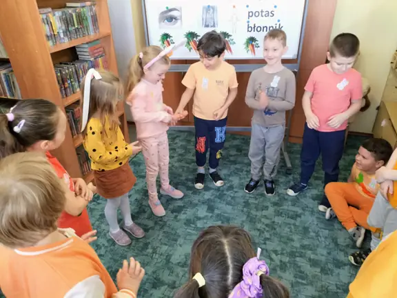 Dzieci z grupy 01 podają sobie marchewkę w rytm muzyki.