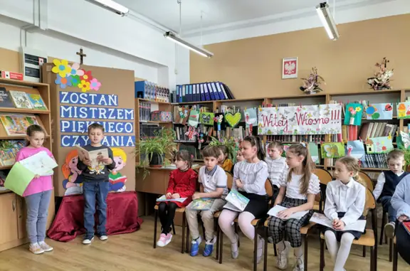 Uczeń z kl. IIIa czyta fragment bajki, jego koleżanka prezentuje klasowa książeczkę.