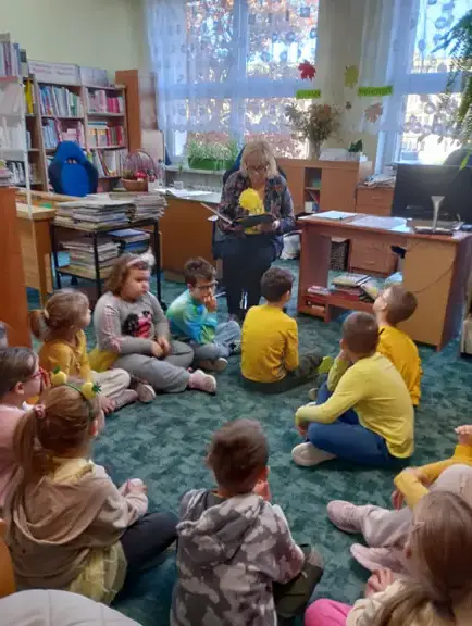 Pani bibliotekarka czyta dzieciom z kl. Ia opowiadanie - Elmer - słoń w kratkę.