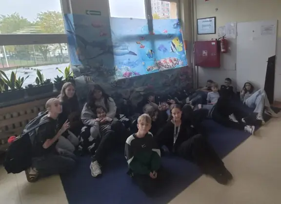 dzieci odpoczywają na korytarzu