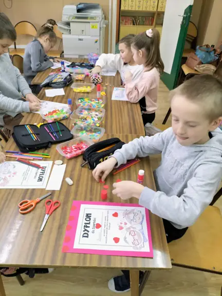 Uczniowie kl. Ib kolorują dyplomy dla babć i ozdabiają je serduszkami.