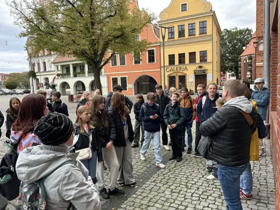 grupa uczniów znajduje się na starym mieście w Stargardzie i słucha opowieści przewodnika