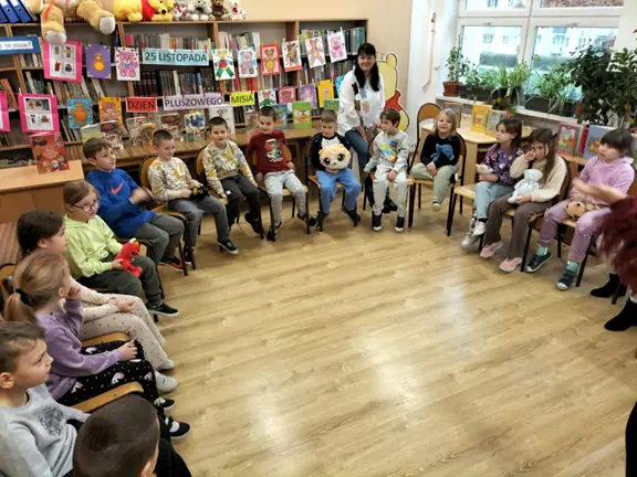 Dzieci z kl. Id z misiami w czytelni szkolnej.