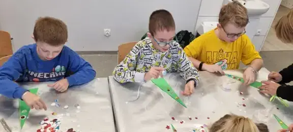 Chłopcy dekorują elementy choinki