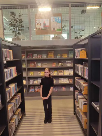 Uczennica wśród zbiorów bibliotecznych