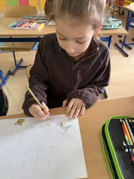 Uczeń z kl. IIb wykonuje ilustracje do przeczytanej książki.