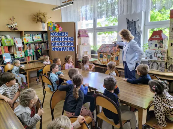 Przedszkolaki wskazują , w których domkach mieszkają bohaterowie bajek.