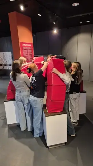 Uczniowie wspólnie budują sklepienie z cegiełek z gąbki