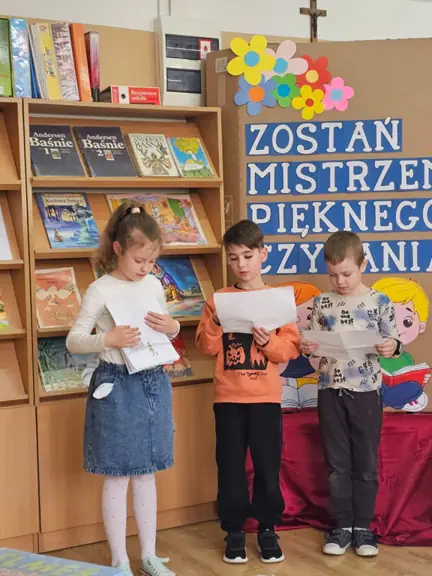 Uczeń kl. Ic czyta fragment bajki, jego koleżanka prezentuje klasową książeczkę.