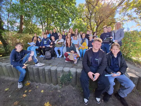 Cała grupa polsko-niemiecka pozuje do zdjęcia w parku.