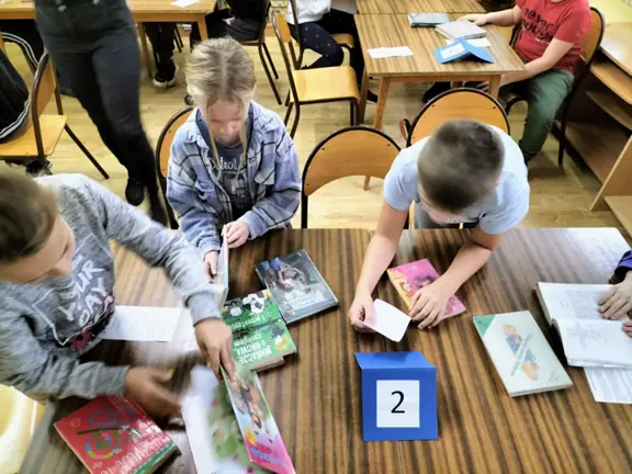 Dzieci sprawdzają do jakiego działu należą wybrane książki.