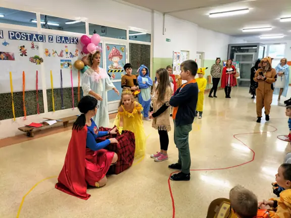 Dziewczynka wklada rączkę do tajemniczego pudełka, aby wyciągnąć rekwizyt z bajki