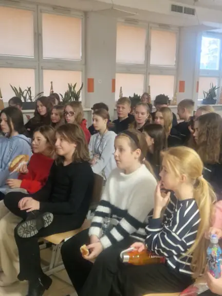 Grupa uczniów wraz z opiekunami dyskutuje na temat teatru