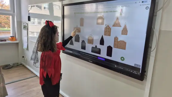 Uczennica dobiera w pary pierniczki z ich cieniami.