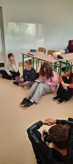 Uczennica kl. VIa czyta koleżankom i kolegom z klasy.