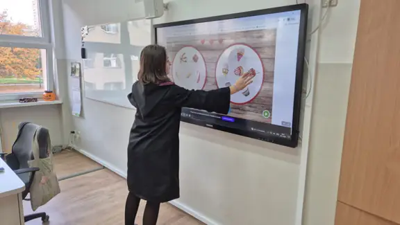 Uczennica z kl. IVb wykonuje zadanie na tablicy multimedialnej.