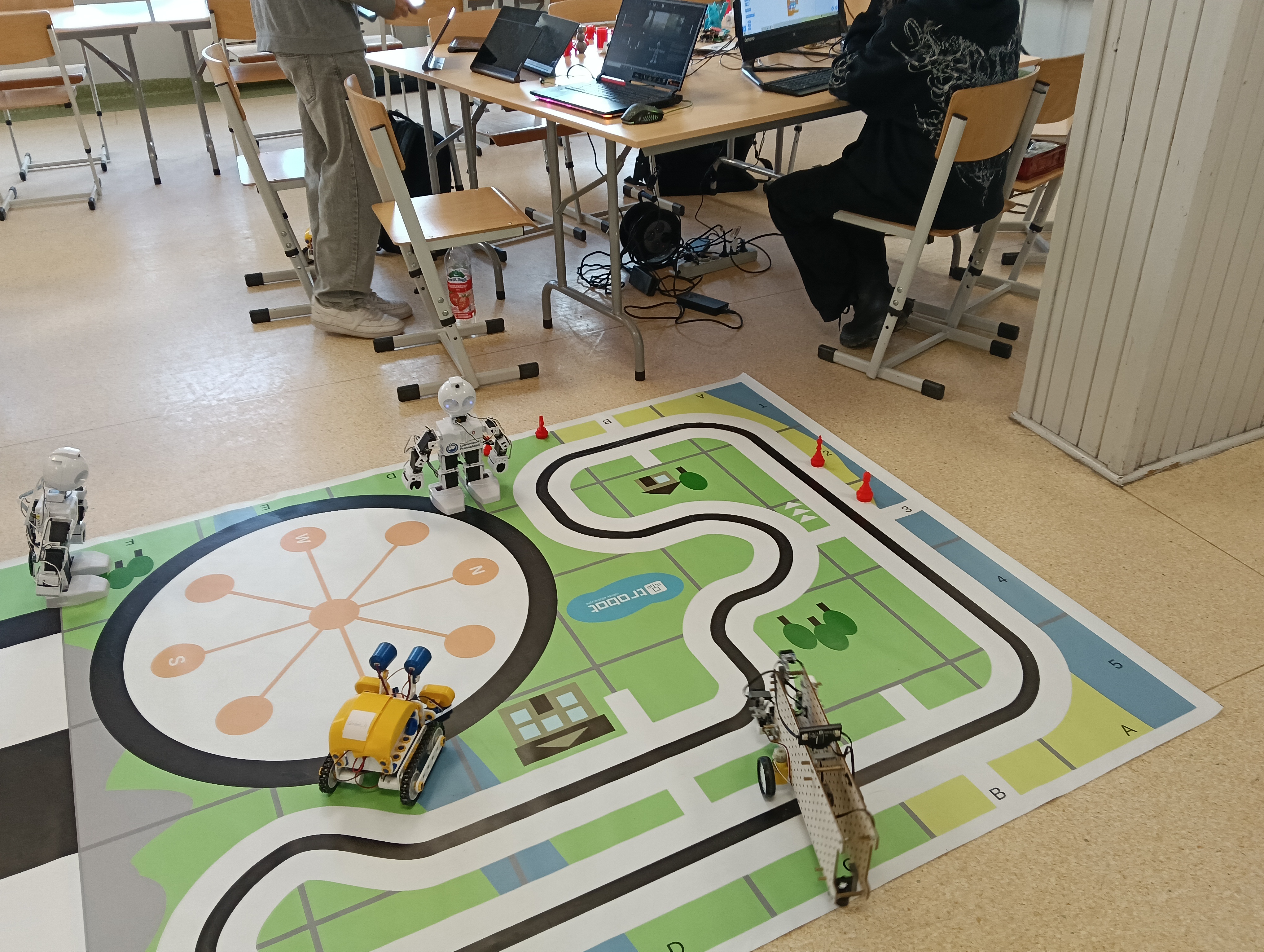 uczeń steruje robotem Skribot na specjalnej macie przeznaczonej dla robotów