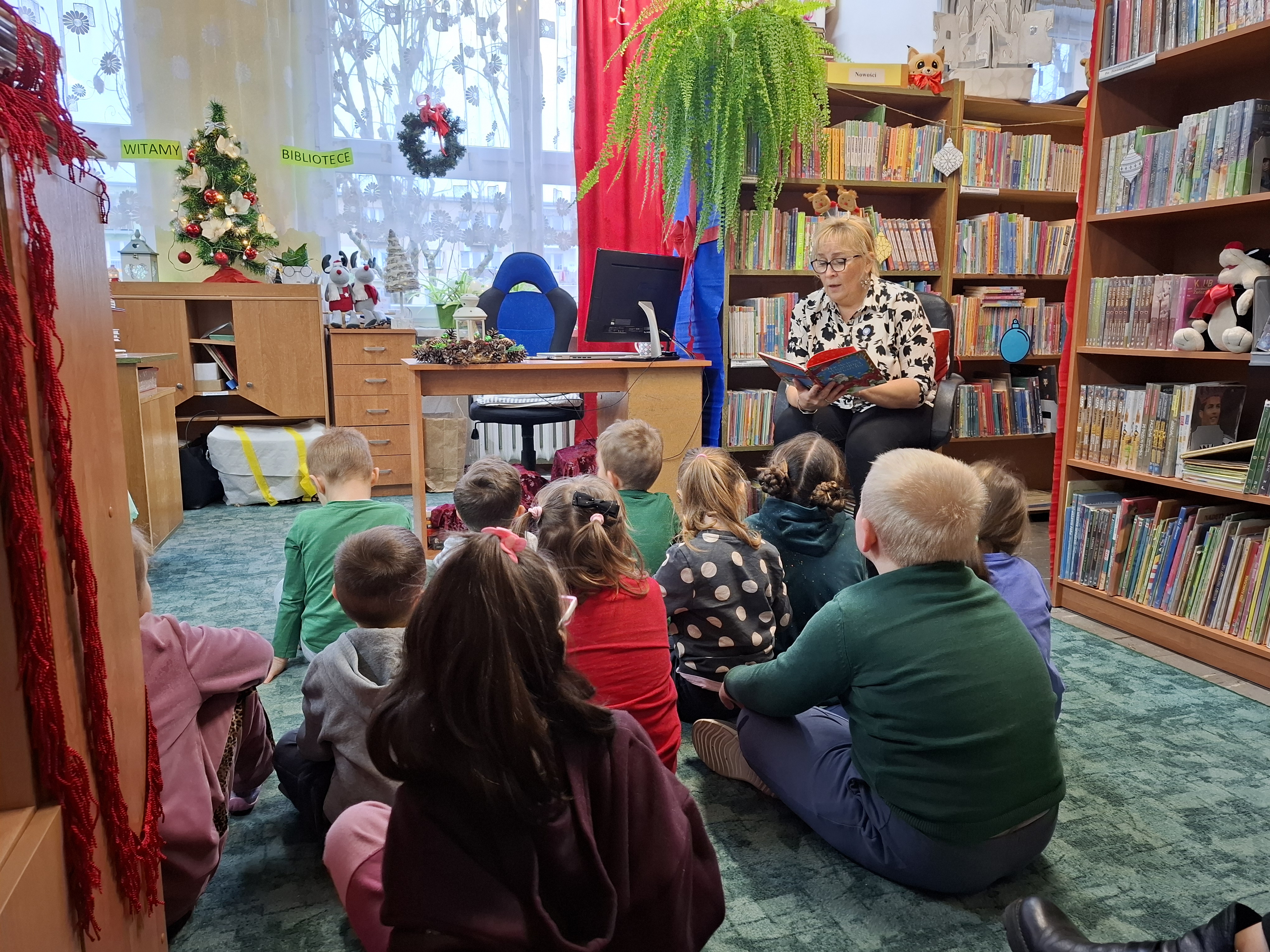 Pani bibliotekarka czyta dzieciom Opowieści wigilijnej Gwiazdki