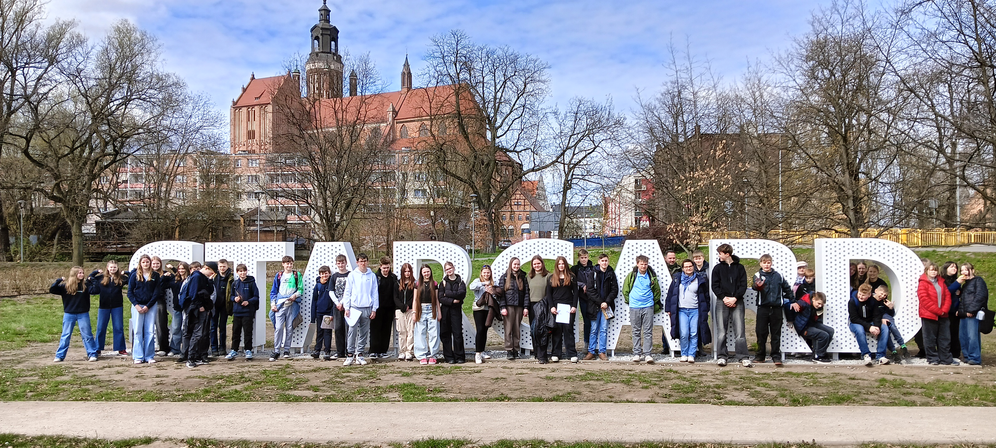 Uczestnicy spotkania na tle zabytków Stargardu.
