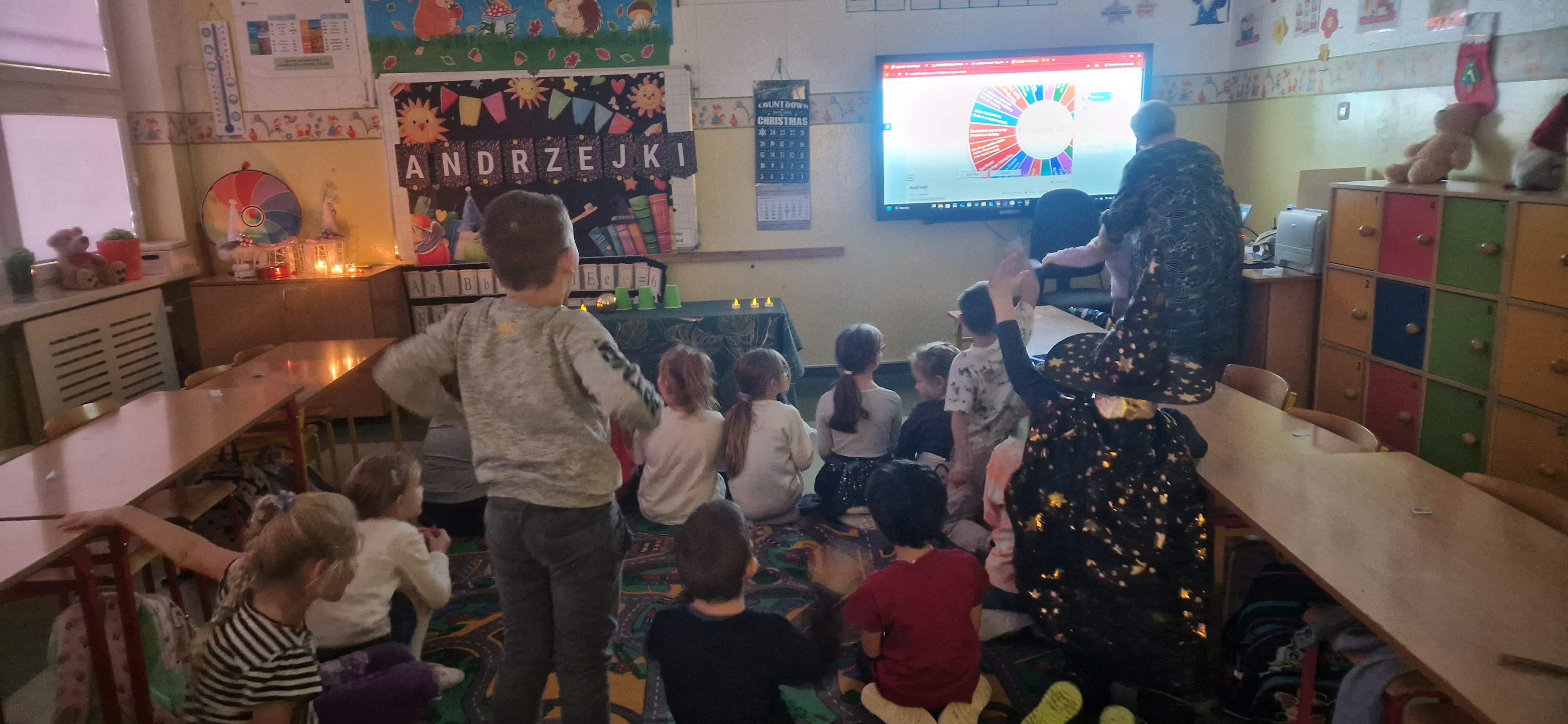 Uczniowie klasy 1 a siedzą na dywanie i czekają na wróżenie