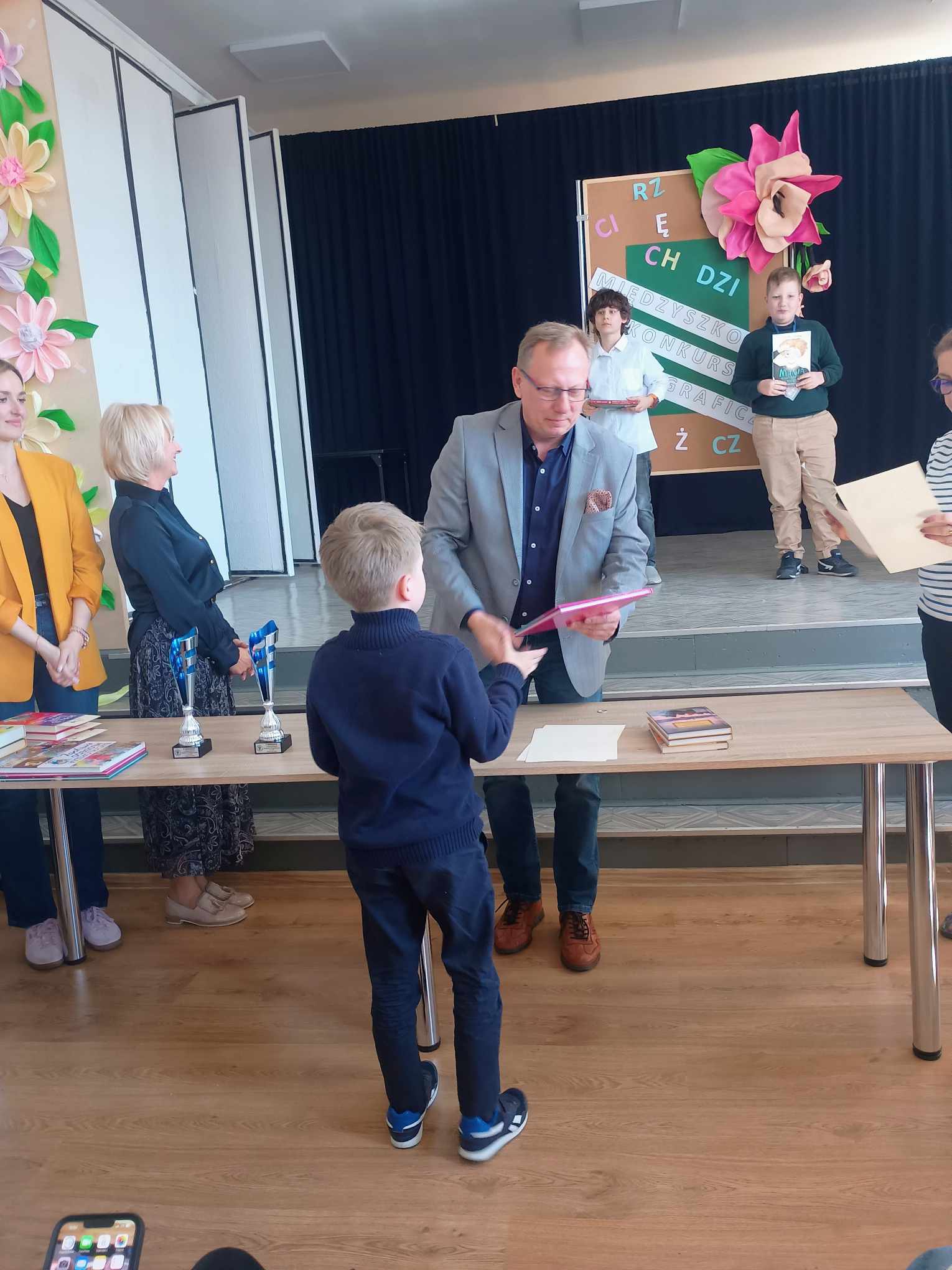 Zwycięzca Międzyszkolnego Konkursu Ortograficznego odbiera gratulacje oraz nagrodę książkową od dyrektora Szkoły Podstawowej numer 3